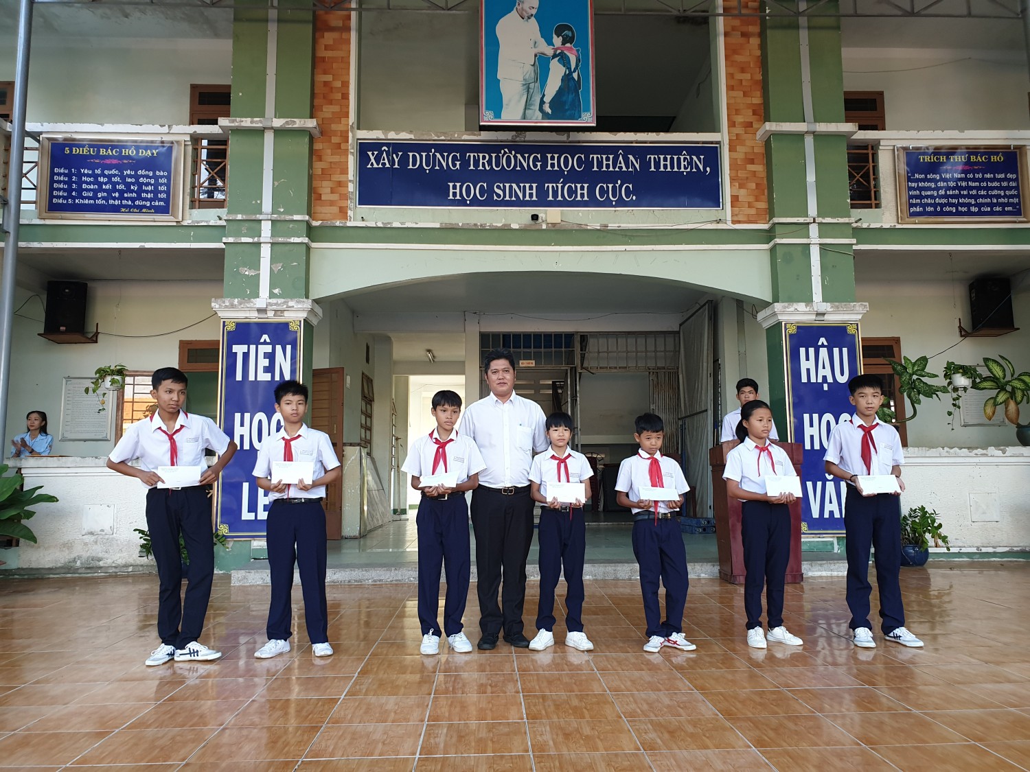 Ông Thái Thi Nhân - Phó chủ tịch UBND phường Chánh Mỹ trao bảo hiểm cho học sinh